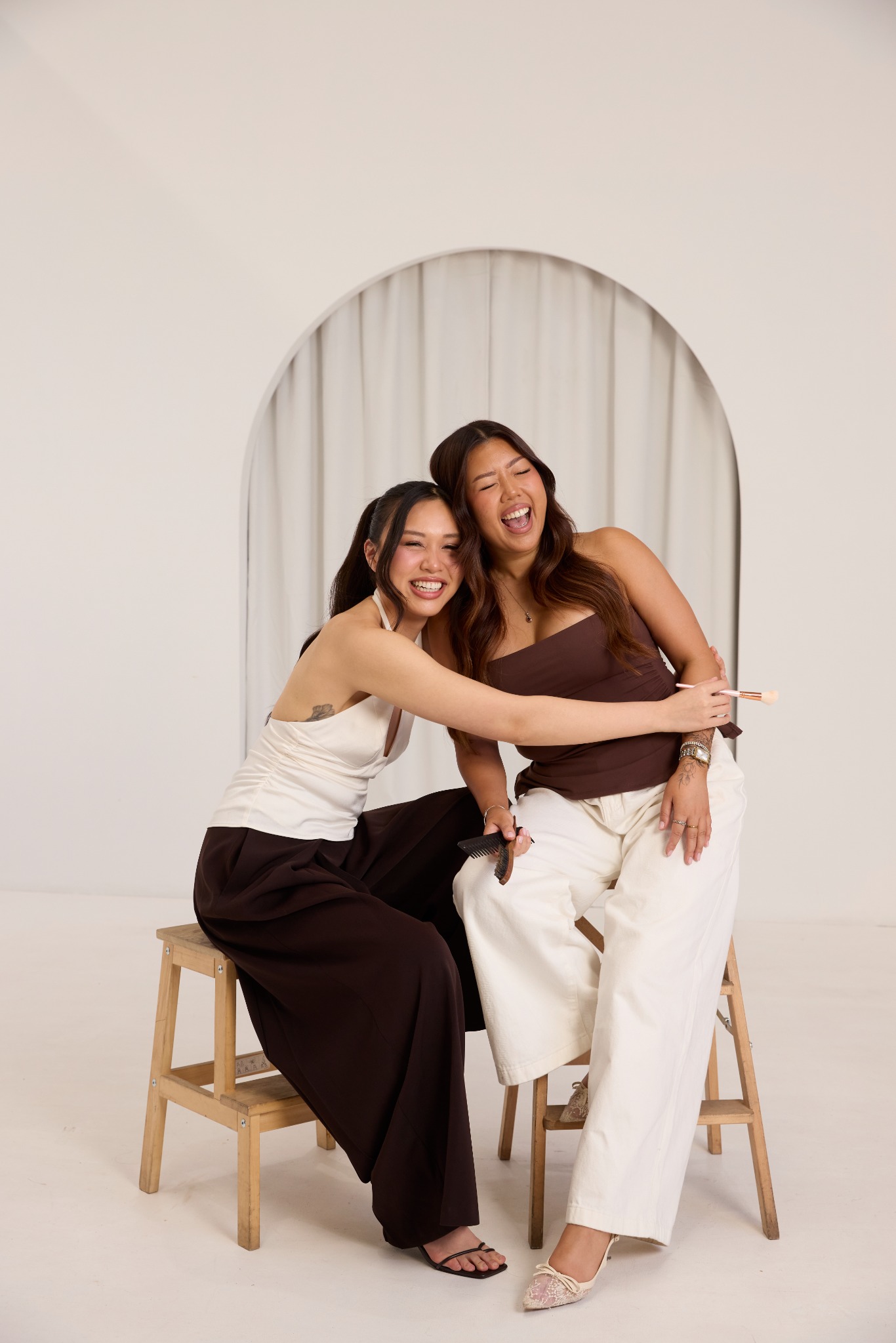 Two UF Styles artists smiling and embracing in their studio